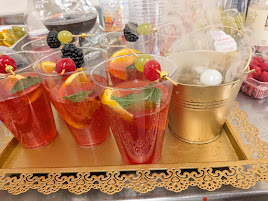 Red mocktails served with fruit and citrus garnishes on a decorative tray